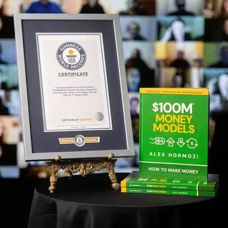 The Guinness World Records certificate beside green copies of $100M Money Models